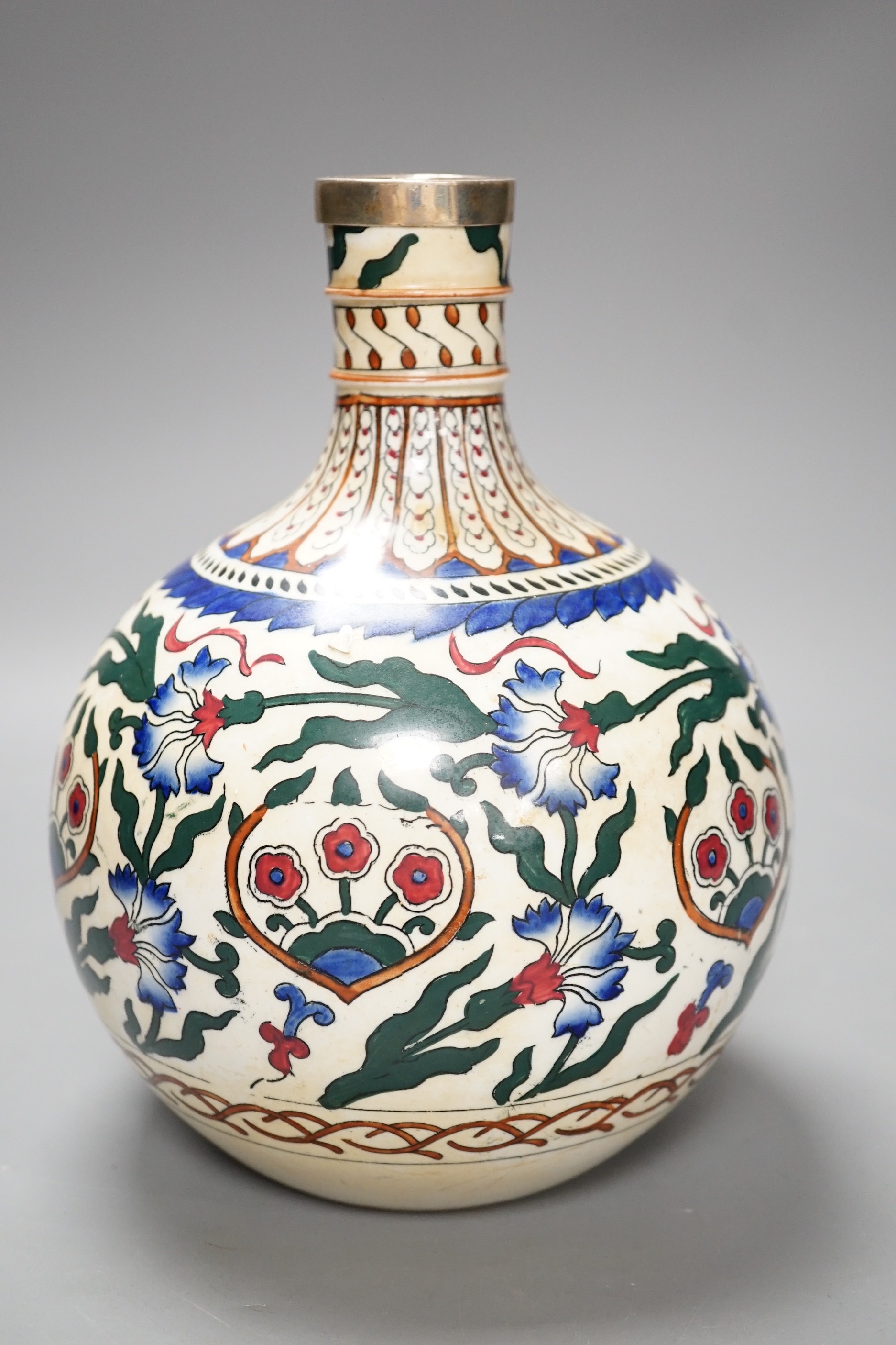 A Continental pottery bottle vase, in Iznik style, ground down with white metal mount. 20cm tall.